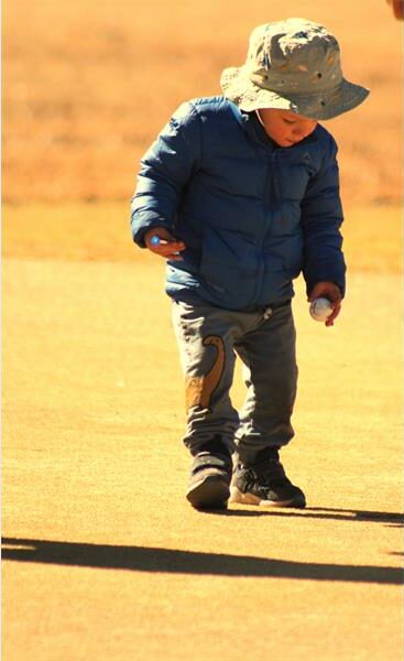 A young boy riding a skateboard down a road.