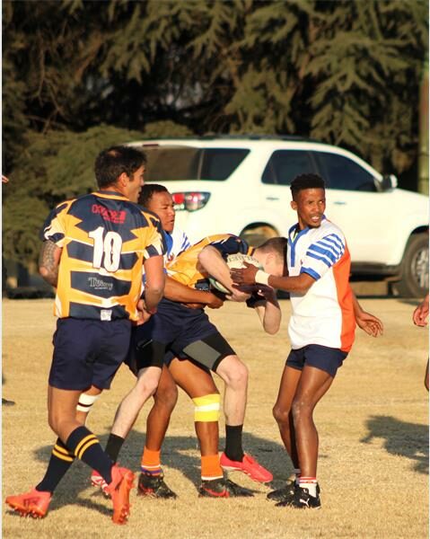 A group of young men playing rugby on a field.