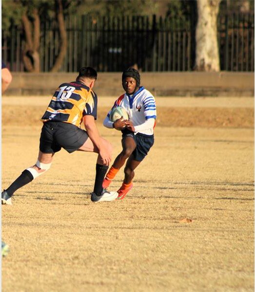 A group of young men playing rugby on a field.