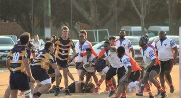 A group of men playing rugby on a field.