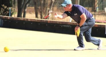 A man in a blue shirt is throwing a ball.
