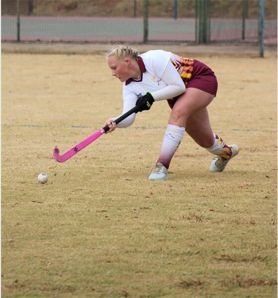 A woman playing field hockey on a field.