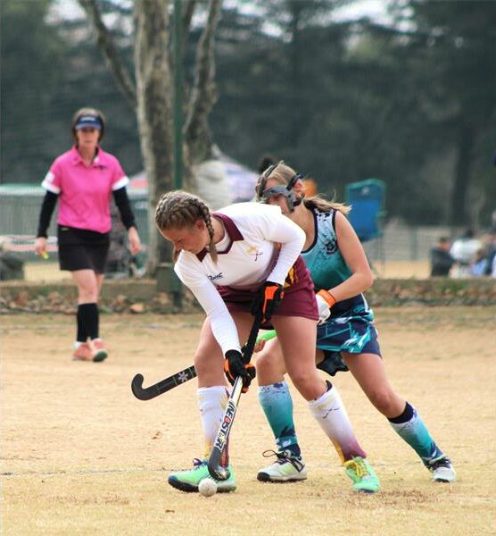 A woman playing field hockey on a field.