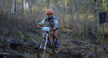 A young man on a mountain bike in the woods.