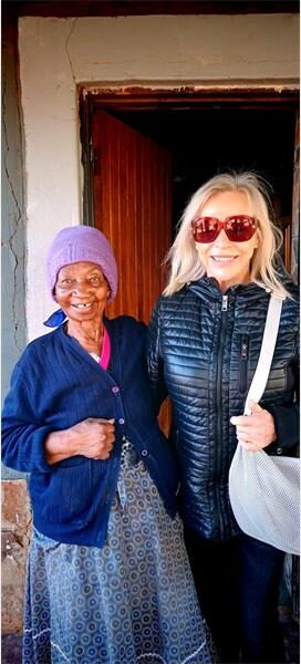Two women standing next to each other in front of a door.