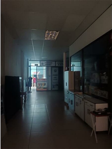A long hallway with a refrigerator and a microwave.