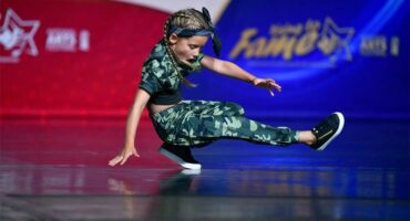 A young girl doing a trick on a skateboard.