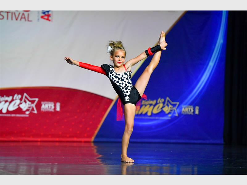 A young girl performing on a stage at a competition.