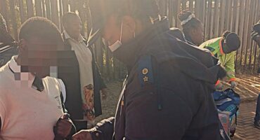 A man in a blue jacket is handing something to a boy.