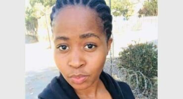 A woman with braids is looking at the camera.