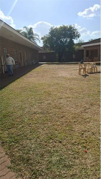 A grassy area with a bench and a fence.