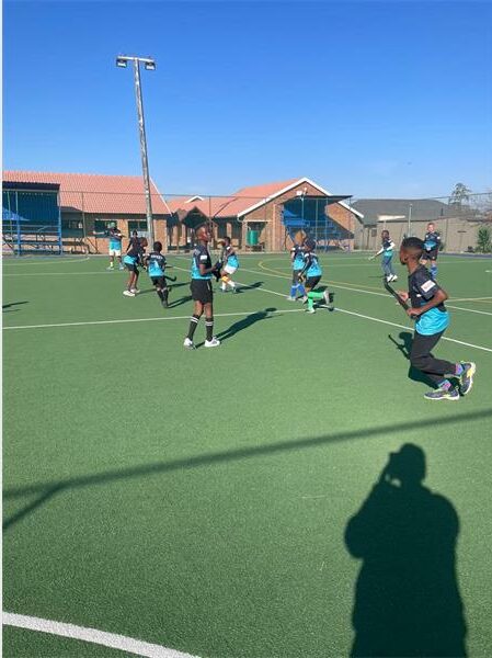 A group of people playing a game of field hockey.