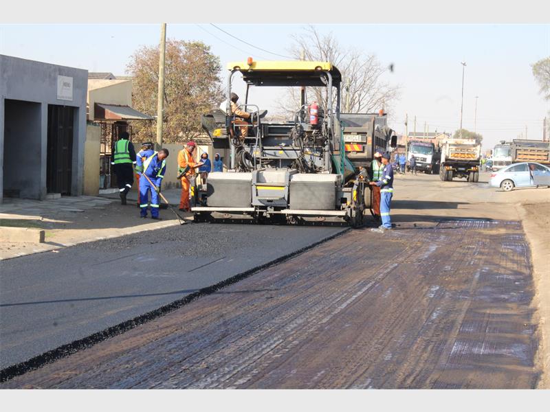 A group of workers are working on a road.