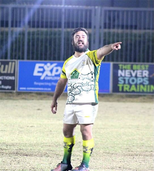 A man in a yellow and green jersey pointing at something.