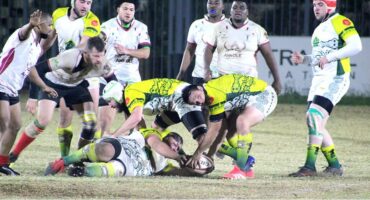 A group of men playing rugby on a field.