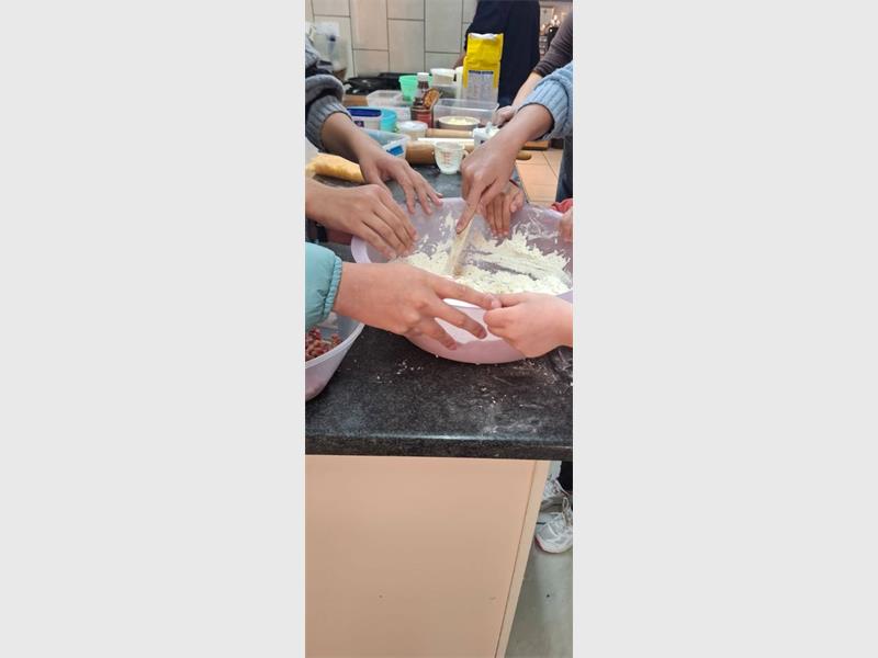 Children are making food in a kitchen.