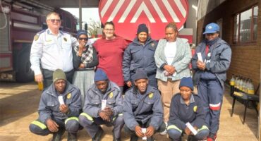 A group of people posing for a photo in front of a fire truck.
