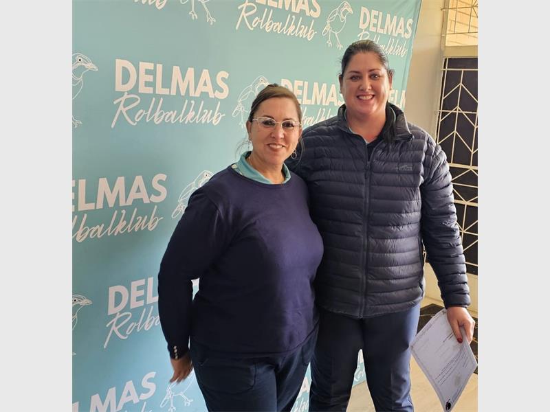 A man and woman standing in front of a blue wall.