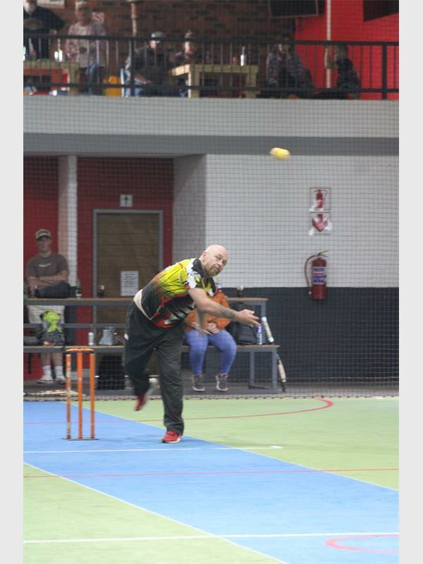 A man in a yellow shirt is throwing a ball.