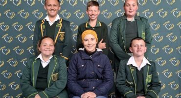 A group of students in school uniforms posing for a photo.