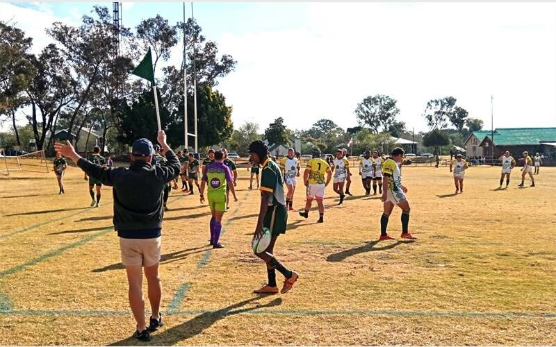 A group of people playing soccer on a field.