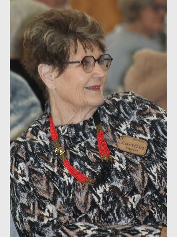 An older woman wearing glasses and a necklace.