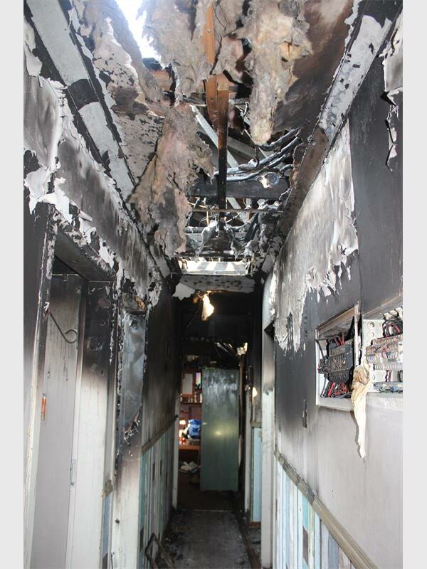 A hallway with burnt walls and a door.