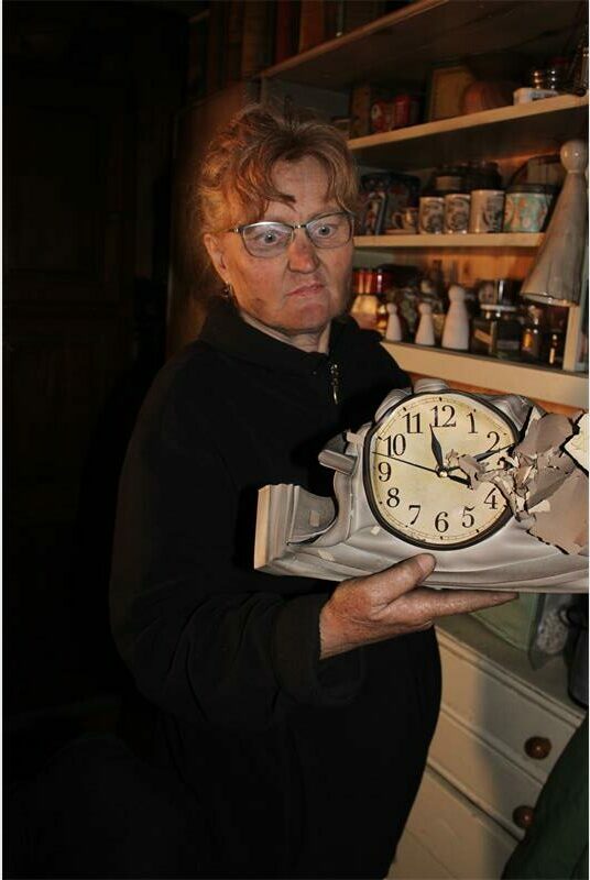 A woman holding a clock.