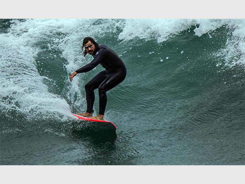 A man riding a surfboard on a wave.
