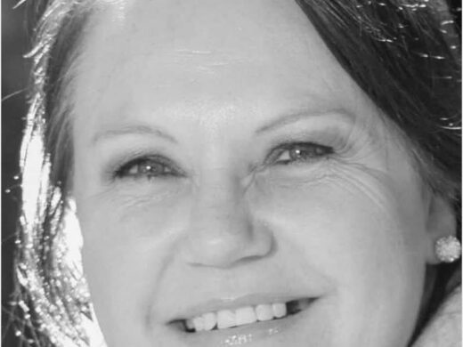 A black and white photo of a woman smiling.