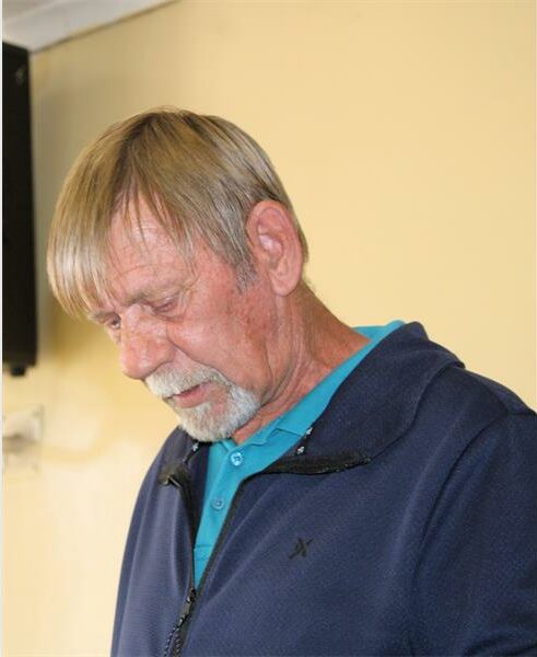 An older man with a beard and a blue jacket.