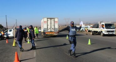 Police officers on the side of the road with traffic cones.