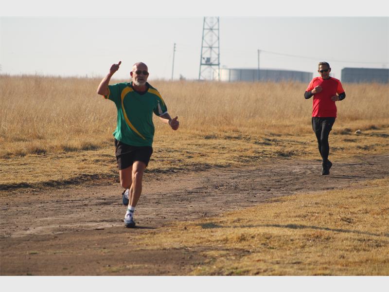 Two men running in the middle of a field.