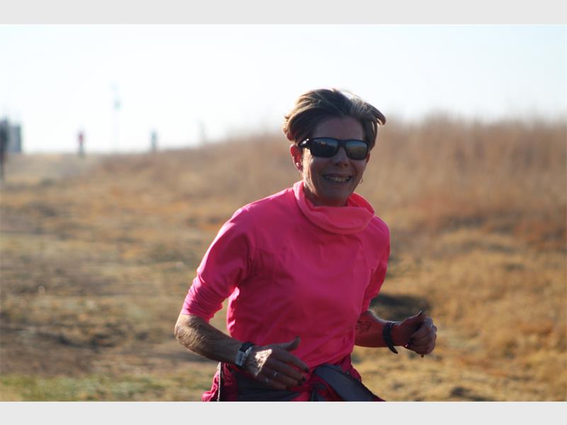 A woman in pink running in a field.