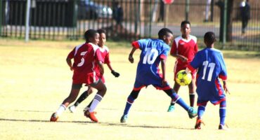 A group of young boys playing soccer on a field.