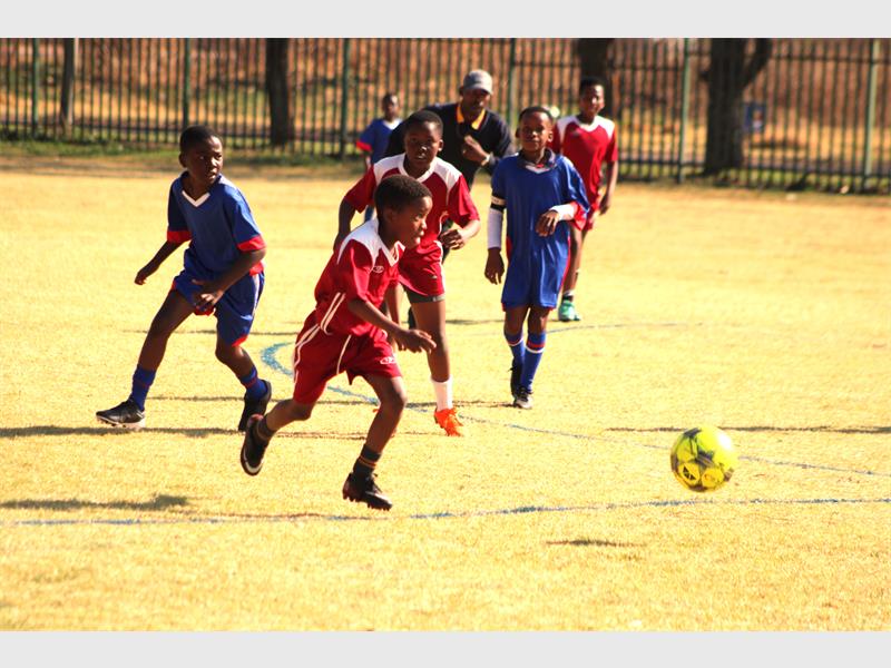 A group of kids playing soccer on a field.
