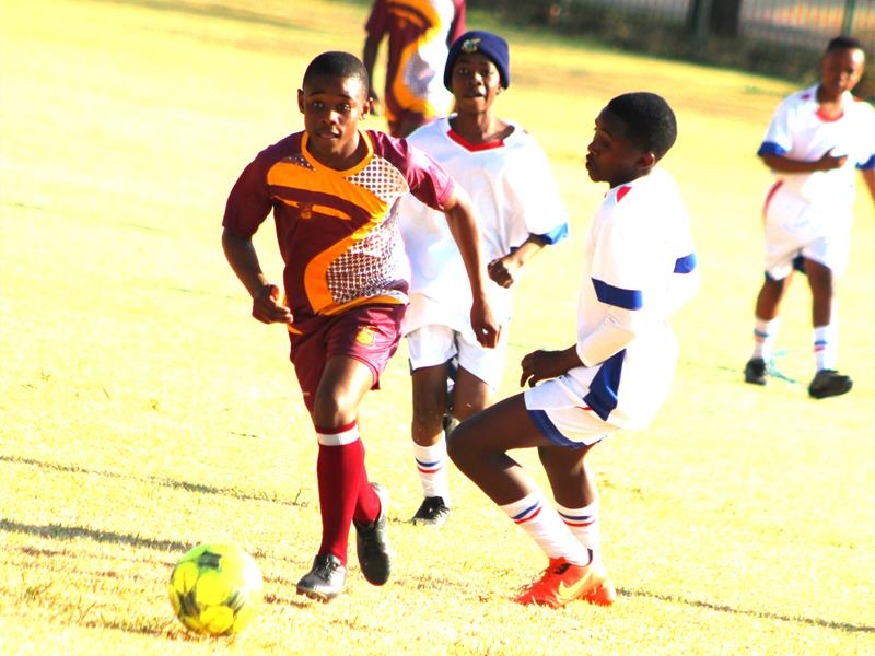A group of young men playing soccer on a field.