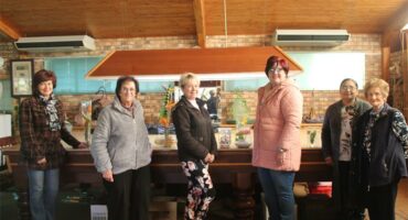 A group of women standing around a table in a restaurant.