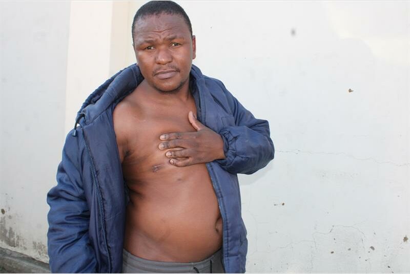A man with his chest open and his hands on his chest.