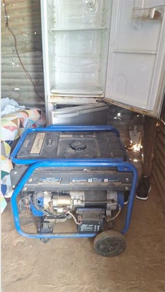 A refrigerator and a generator sitting next to each other.