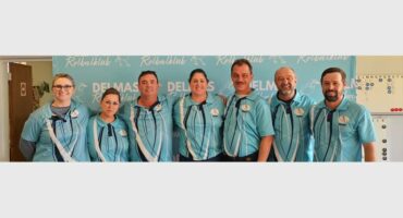 A group of people in blue shirts standing next to each other.