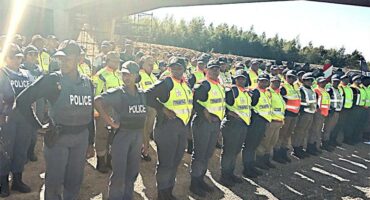 A group of police officers standing in front of a bridge.