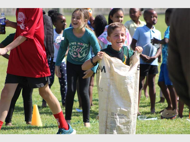 A boy is holding a bag of sand.