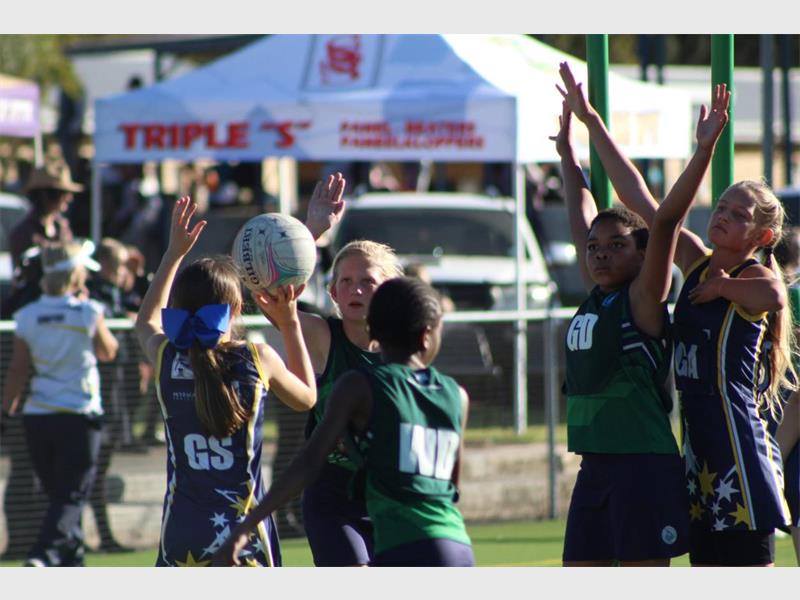 A group of girls playing a game of rugby.