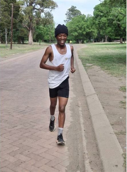Teenage boy wearing a white vest running.
