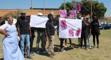 People with banners picket outside a court house