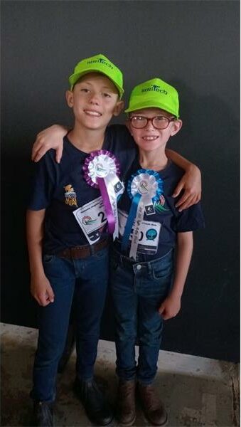 Twee seuns met groen pette en rosette.