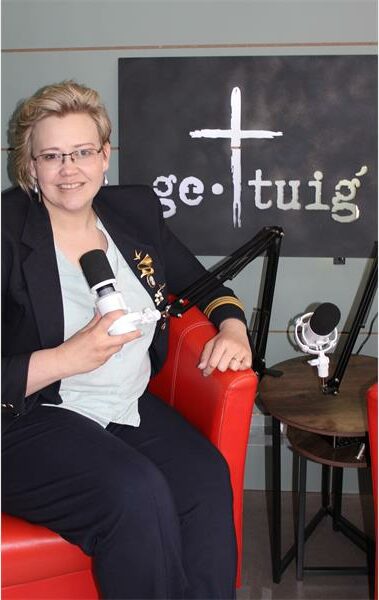 Woman with a microphone and a sign with a cross