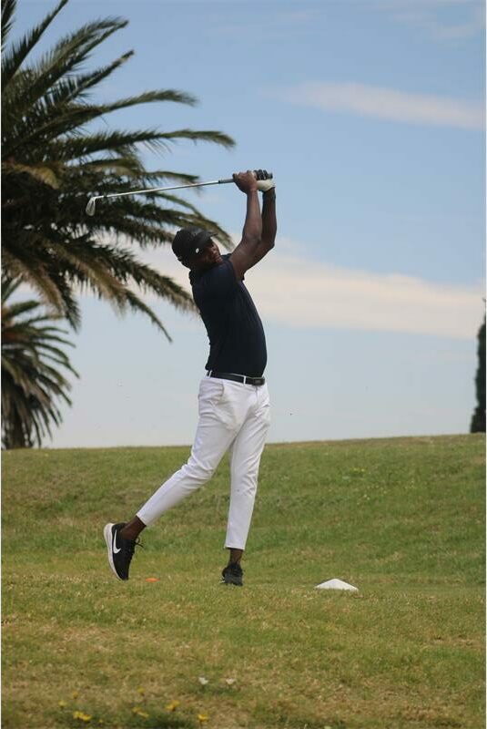 man tees off