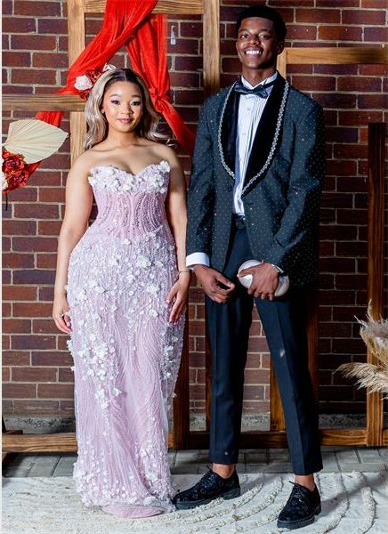 couple dressed up. Girl in pink dress and boy in tapered suit
